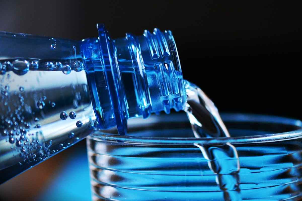Bottiglia d'acqua con bicchiere