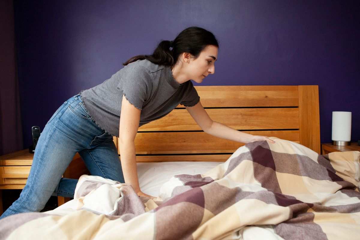 Donna provvede a rifare il letto