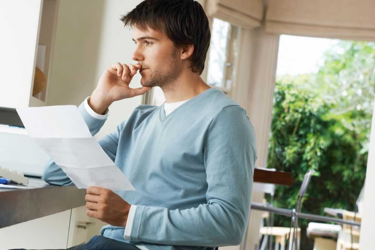 uomo che pensa con un documento in mano
