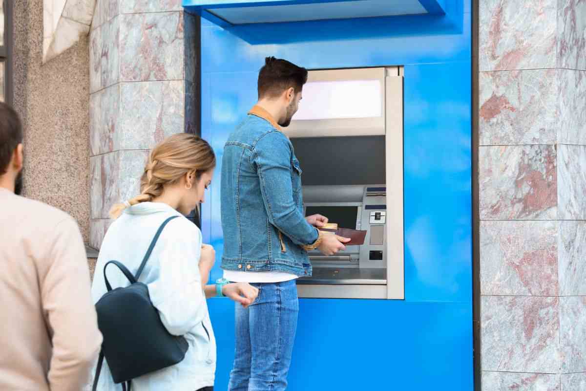 persone in fila al bancomat