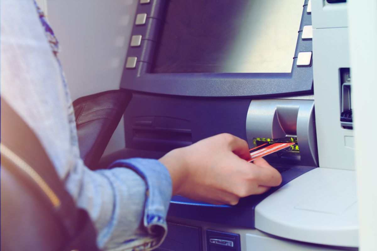 una persona mette la scehda al bancomat