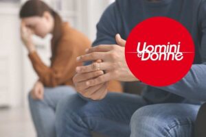 una coppia si lascia e nel cerchietto il logo di uomini e donne
